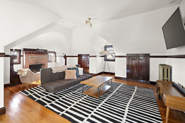 9 Prospect St, Winchester, MA 01890 - living room with wood finished floors, lofted ceiling, a brick fireplace, and baseboards