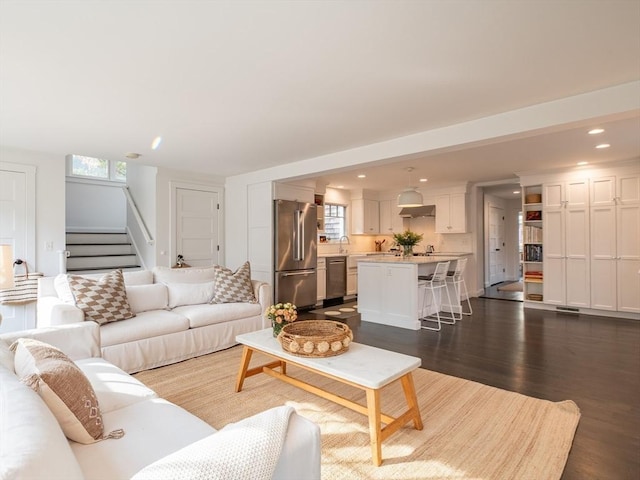 living room with recessed lighting, stairway, and dark wood-style flooring