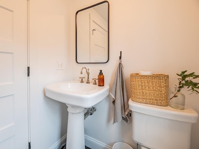 bathroom featuring toilet and baseboards