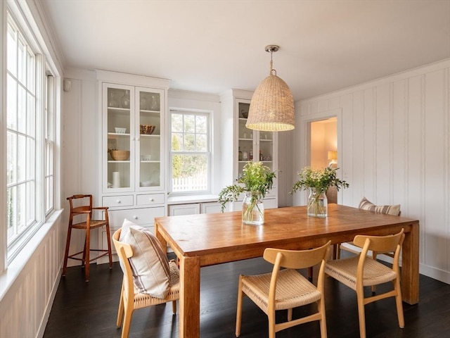 dining space featuring dark wood-style floors and crown molding