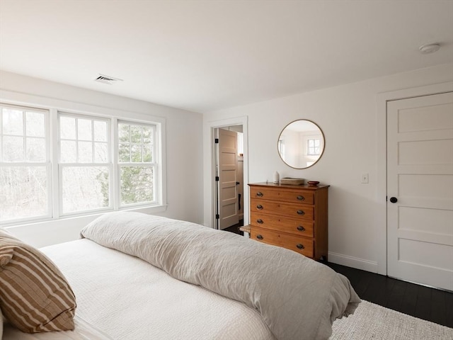 bedroom featuring dark wood-style floors, visible vents, and baseboards