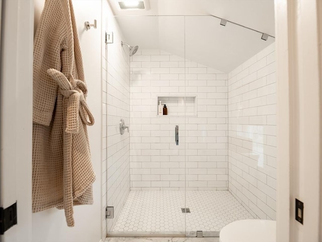 bathroom featuring visible vents, toilet, a shower stall, and vaulted ceiling