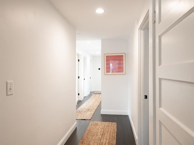 corridor with dark wood-style floors, recessed lighting, and baseboards