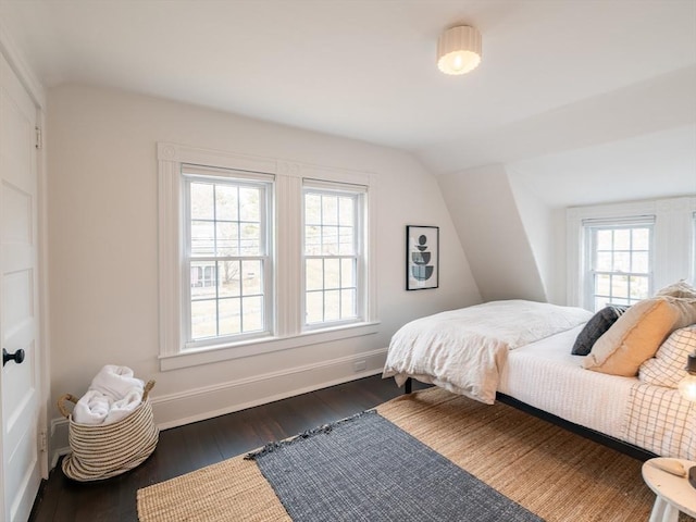 bedroom featuring baseboards, lofted ceiling, and dark wood-style floors