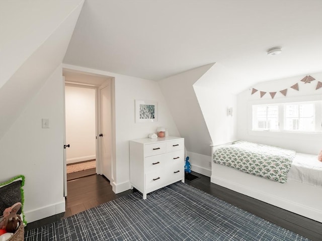 bedroom with dark wood-type flooring, baseboards, and vaulted ceiling