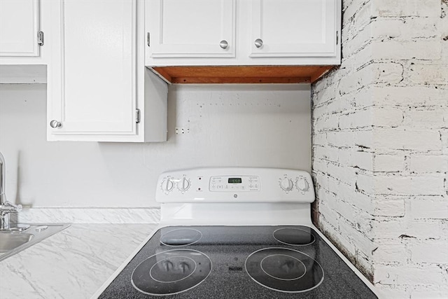 34 Worcester Rd, Charlton, MA 01507 - kitchen view of range, white cabinetry, and brick wall