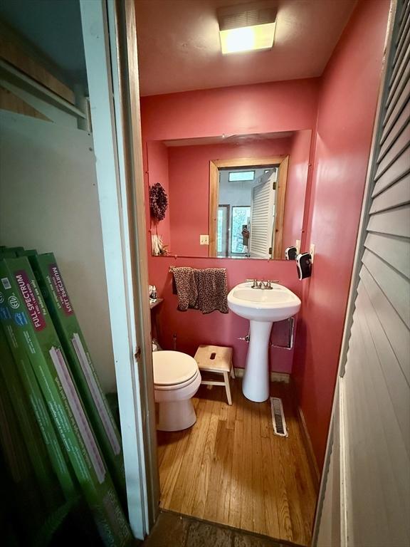 23 Partridge Hill Rd, Dudley, MA 01571 - half bathroom featuring toilet and wood finished floors