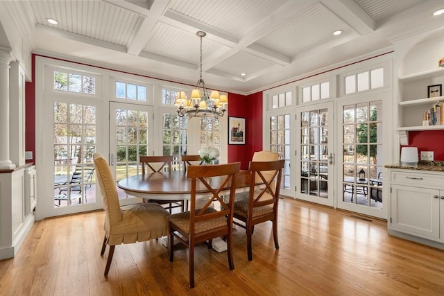 dining room with light wood-type flooring, beamed ceiling, a notable chandelier, coffered ceiling, and decorative columns