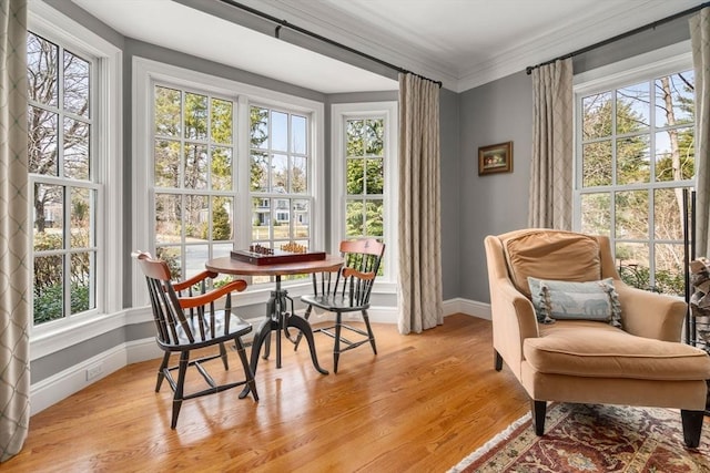 sitting room with light wood-style flooring, baseboards, a healthy amount of sunlight, and ornamental molding