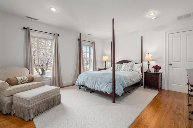 bedroom with recessed lighting, visible vents, baseboards, and light wood finished floors