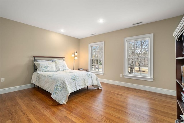 bedroom featuring wood finished floors, recessed lighting, baseboards, and visible vents