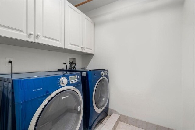 washroom with cabinet space and separate washer and dryer