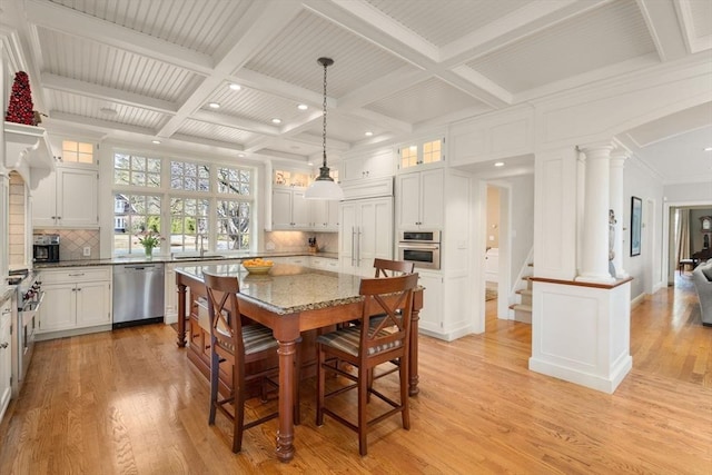 dining area featuring coffered ceiling, light wood finished floors, beam ceiling, decorative columns, and ornamental molding