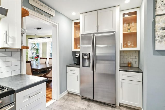 52 Harvard St, Chicopee, MA 01020 - kitchen featuring stainless steel fridge with ice dispenser, dark countertops, white cabinetry, tasteful backsplash, and glass insert cabinets