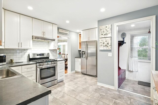 52 Harvard St, Chicopee, MA 01020 - kitchen with appliances with stainless steel finishes, under cabinet range hood, backsplash, white cabinetry, and recessed lighting