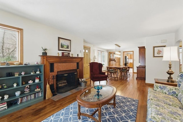 living area featuring hardwood / wood-style flooring, a brick fireplace, and a wealth of natural light