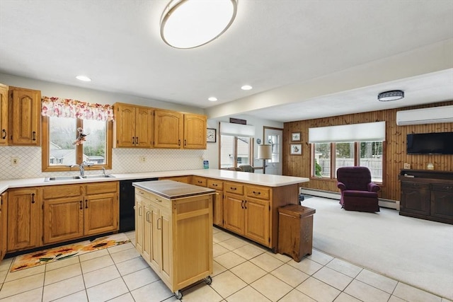 kitchen with open floor plan, a wall mounted air conditioner, black dishwasher, a peninsula, and a sink