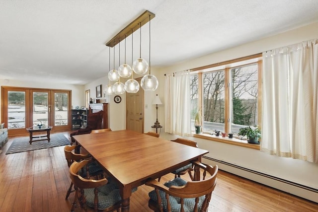 dining area featuring a baseboard heating unit and hardwood / wood-style flooring