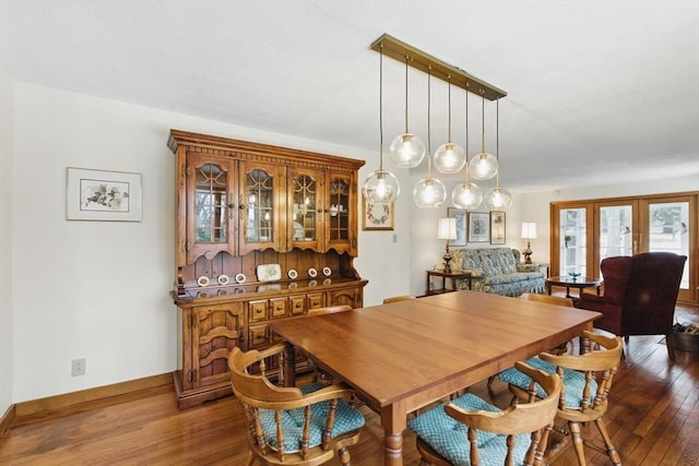 dining space with baseboards and wood-type flooring