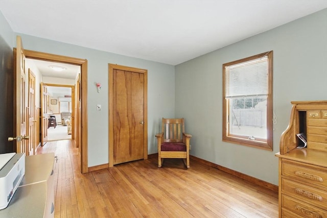 living area featuring light wood finished floors and baseboards