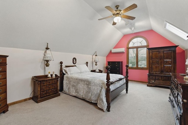 bedroom featuring baseboards, lofted ceiling with skylight, an AC wall unit, and light carpet