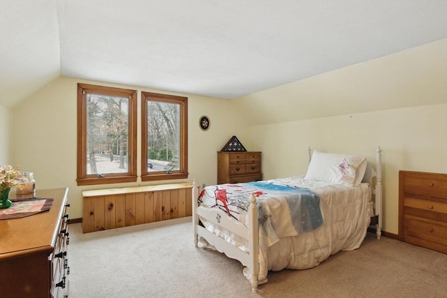 bedroom featuring lofted ceiling, baseboards, and light carpet