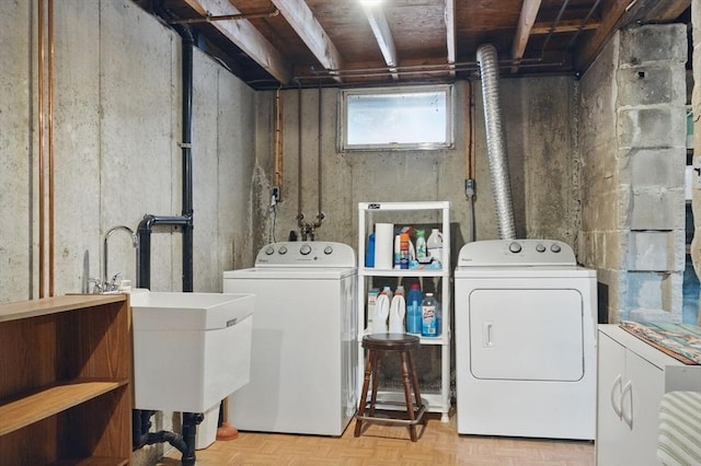 washroom featuring laundry area, washer and dryer, and a sink