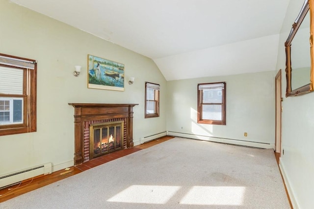 unfurnished living room with baseboard heating, vaulted ceiling, carpet flooring, and a fireplace