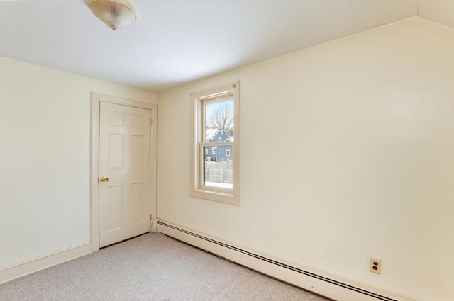 carpeted empty room featuring baseboard heating and lofted ceiling