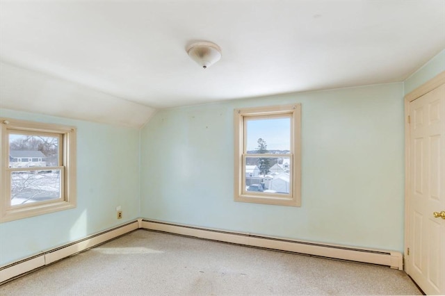 spare room featuring a baseboard radiator and lofted ceiling