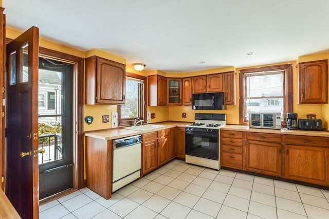 kitchen featuring sink, white appliances, and light tile patterned floors