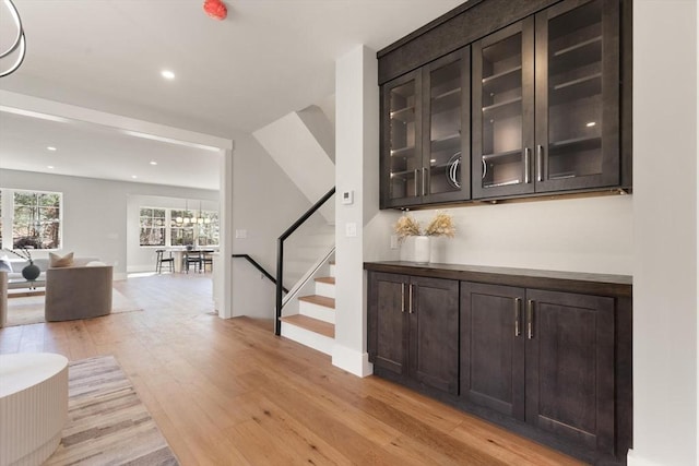 bar featuring dark brown cabinets and light wood-type flooring