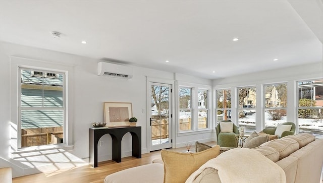 living room with a healthy amount of sunlight, light wood-style flooring, recessed lighting, and a wall mounted air conditioner