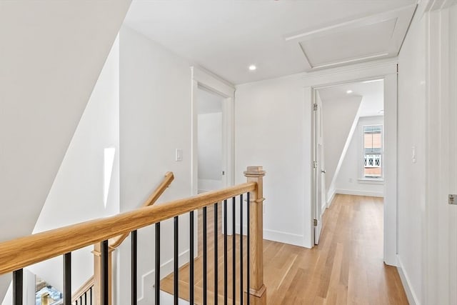 hall with light wood-style flooring, recessed lighting, an upstairs landing, baseboards, and attic access