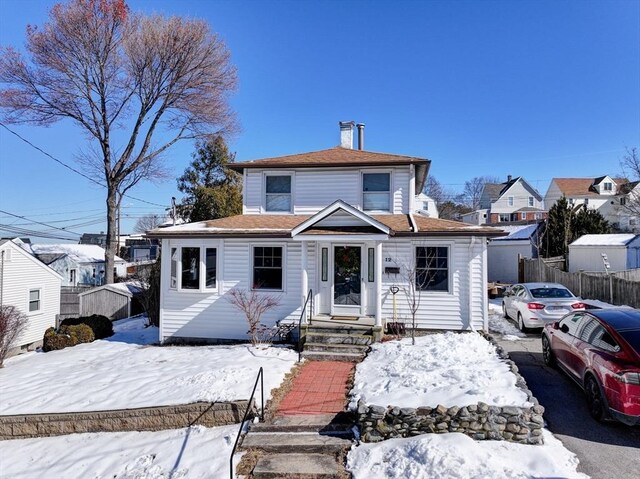 view of front of house featuring a chimney and fence