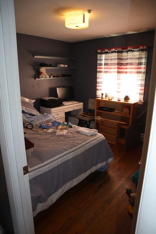 bedroom with dark hardwood / wood-style flooring