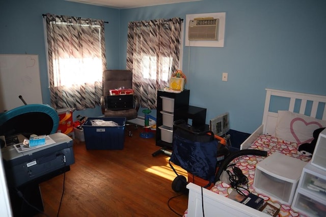 bedroom featuring hardwood / wood-style flooring, a wall unit AC, and multiple windows