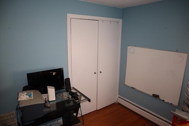 office space with dark wood-type flooring and baseboard heating