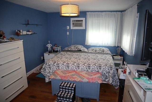 bedroom featuring dark hardwood / wood-style floors and a wall unit AC