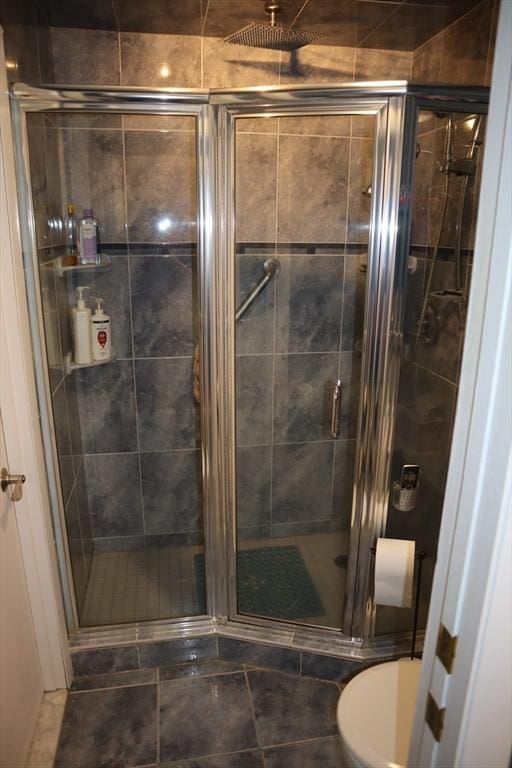 bathroom with an enclosed shower and toilet