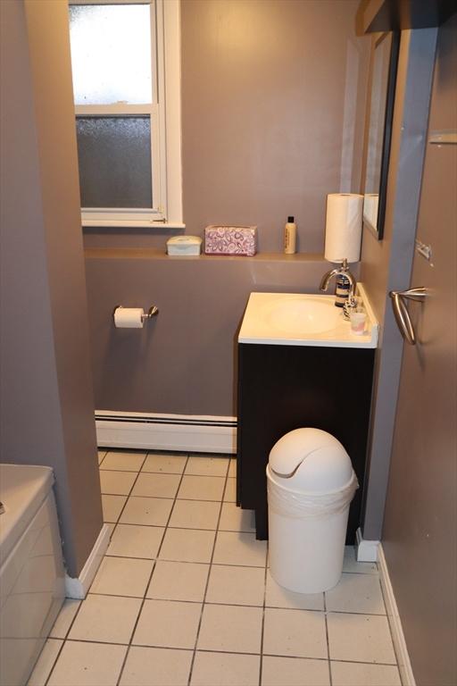 bathroom with a baseboard radiator, tile patterned floors, and vanity