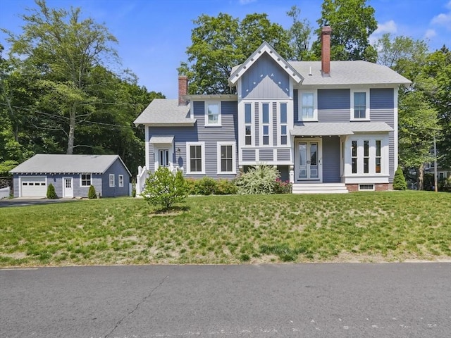 33 Grove St, Merrimac, MA 01860 - view of front of property with a chimney, an outbuilding, a front yard, and board and batten siding