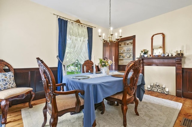 33 Grove St, Merrimac, MA 01860 - dining area featuring a chandelier, light wood-style flooring, and a wainscoted wall