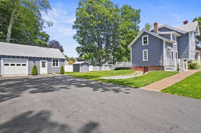 33 Grove St, Merrimac, MA 01860 - view of home's exterior featuring driveway, a garage, a chimney, a yard, and a storage unit