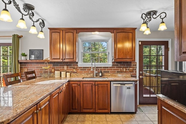 kitchen featuring decorative backsplash, stainless steel dishwasher, sink, light tile patterned floors, and decorative light fixtures