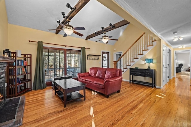 living room featuring a textured ceiling, ceiling fan, crown molding, light hardwood / wood-style flooring, and lofted ceiling