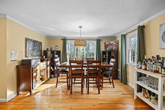 dining space with crown molding and light hardwood / wood-style floors