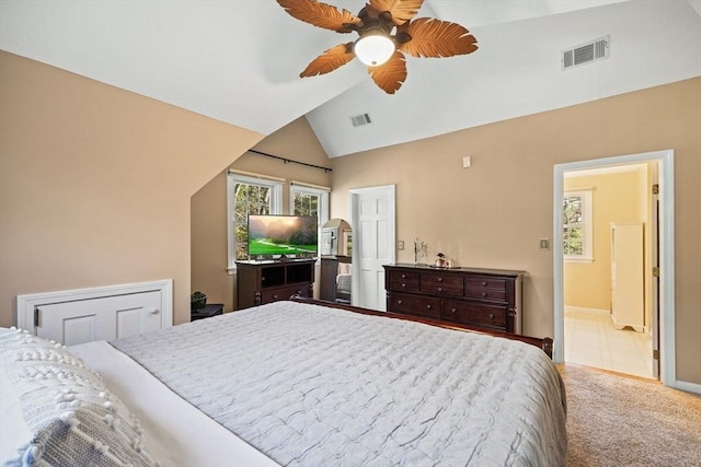 carpeted bedroom with ensuite bath, vaulted ceiling, and ceiling fan