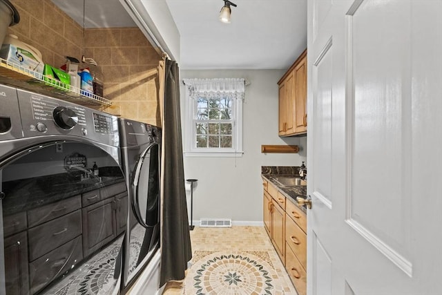 clothes washing area with separate washer and dryer, sink, and light tile patterned floors