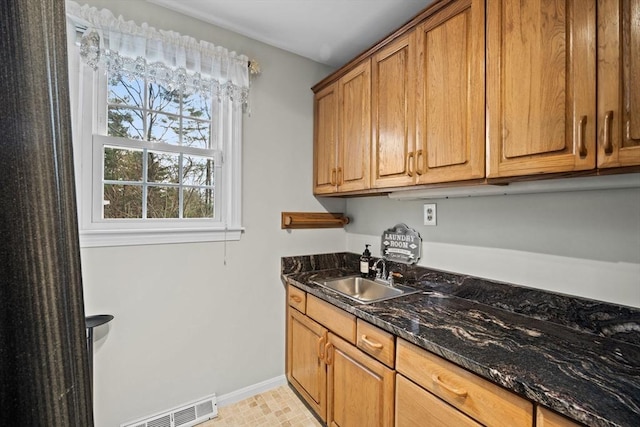 kitchen with dark stone countertops and sink